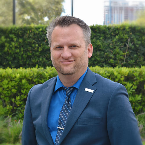 A man wearing a suit and tie smiling at the camera