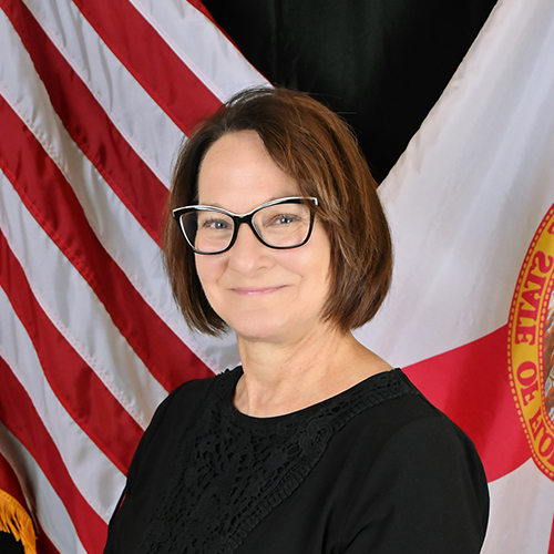 A person standing in front of a flag