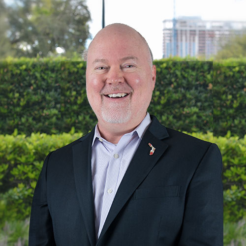 A man wearing a suit and tie smiling at the camera