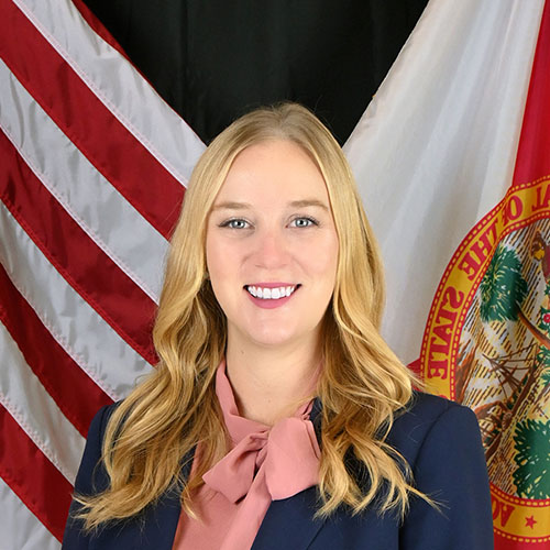 A woman standing in front of a flag