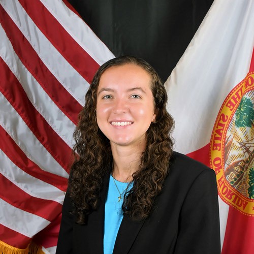 A person standing in front of a flag