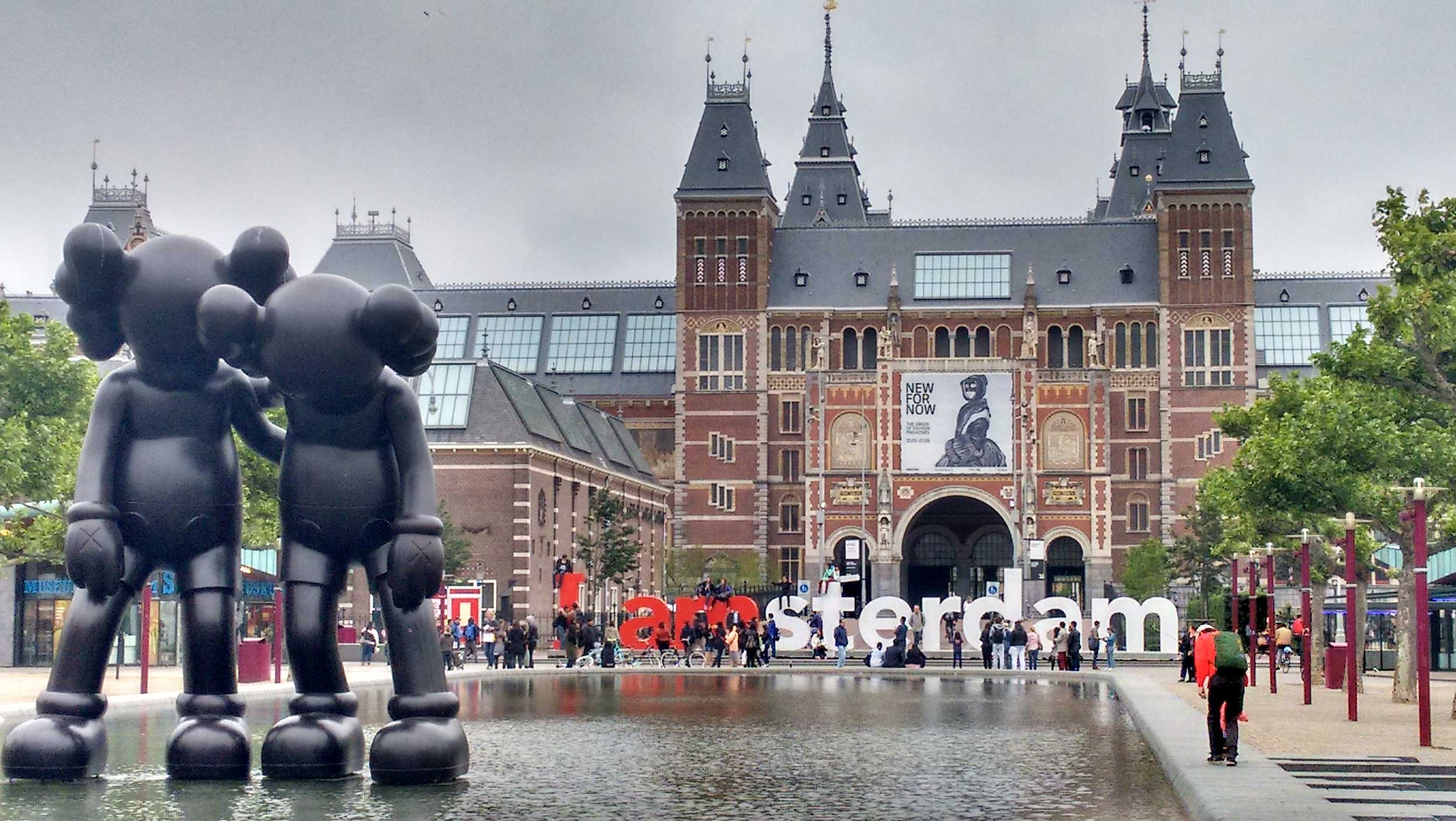 A group of people walking in front of Rijksmuseum