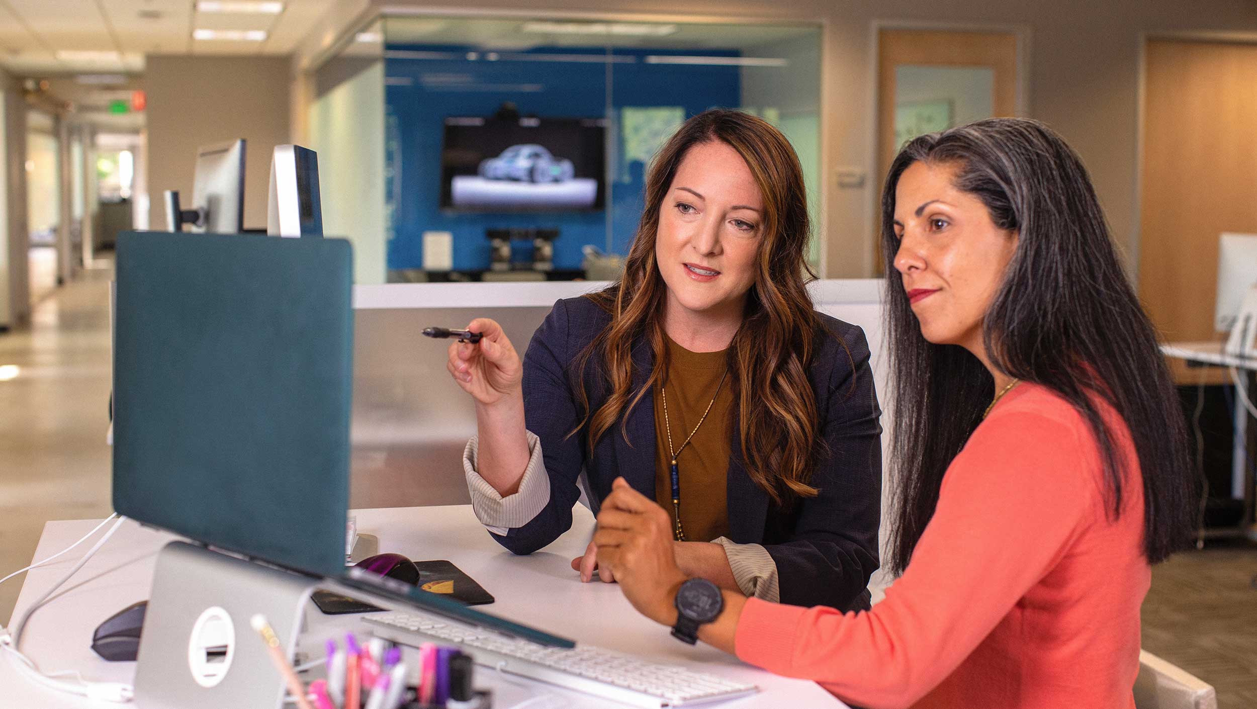 Two women looking at a laptop while working in Florida
