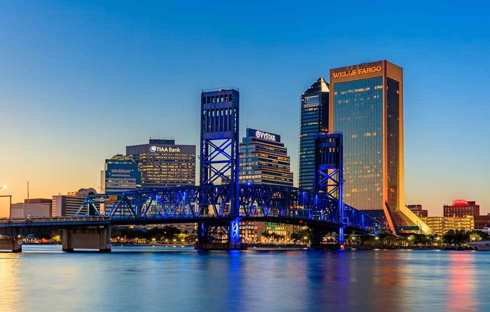 A bridge over a body of water with a city in the background